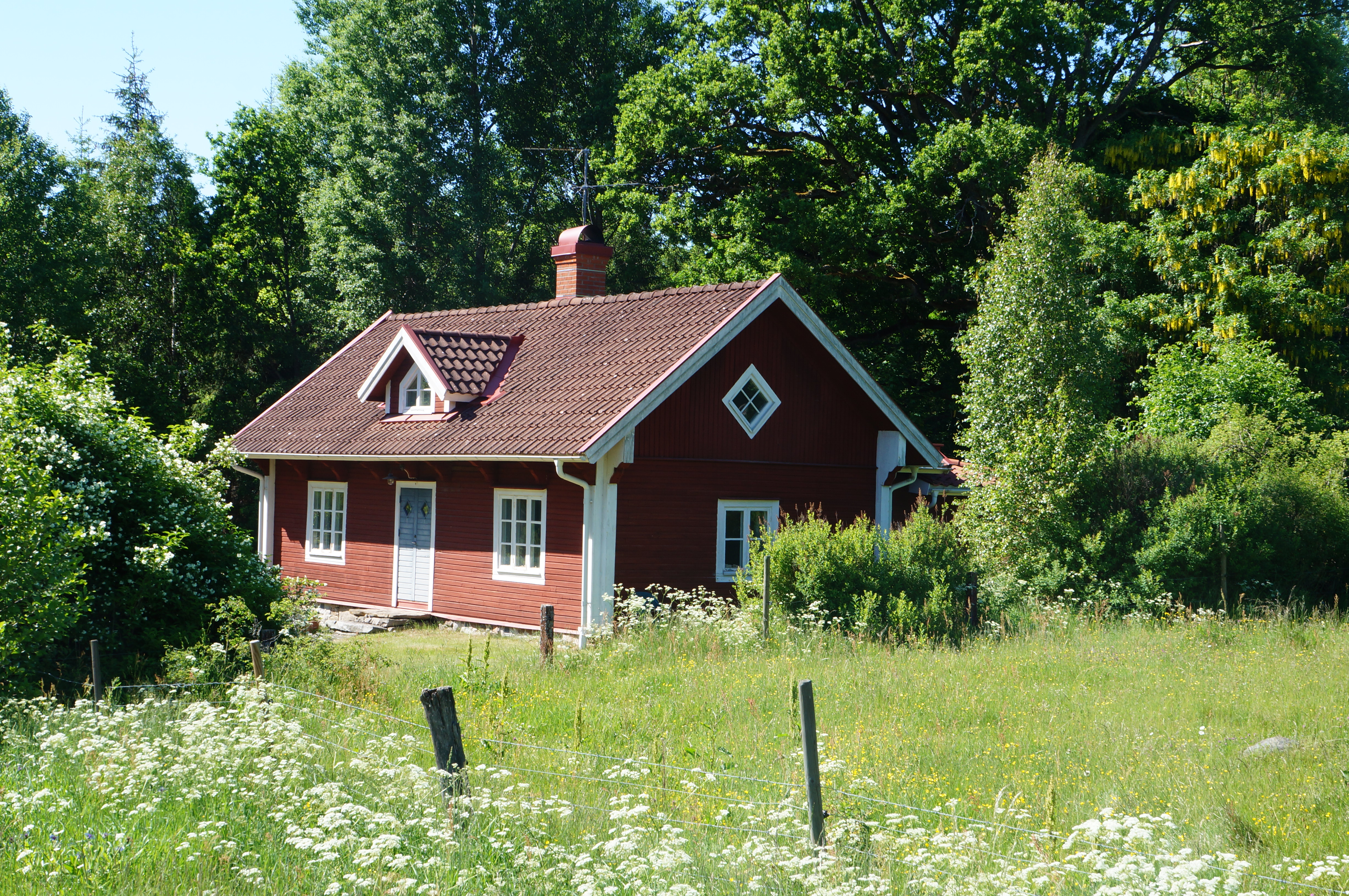 en liten röd stuga på landet