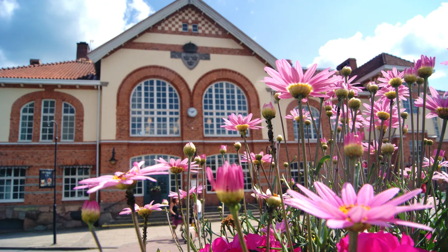 rosa blommor framför alvesta stationshus